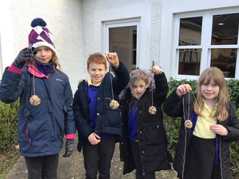 Four students from St John’s primary school holding bird feeders that they have made as part of the seven-step programme for the green flag