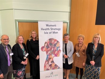 Spotlight on Women’s Health conference guest speakers standing in beside a banner that reads Women’s Health Isle of Man